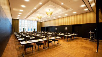 Meeting in the Goldene Saal of the ATLANTIC Grand Hotel Bremen  Modern conference room in the ATLANTIC Grand Hotel Bremen with elegant seating and large windows.