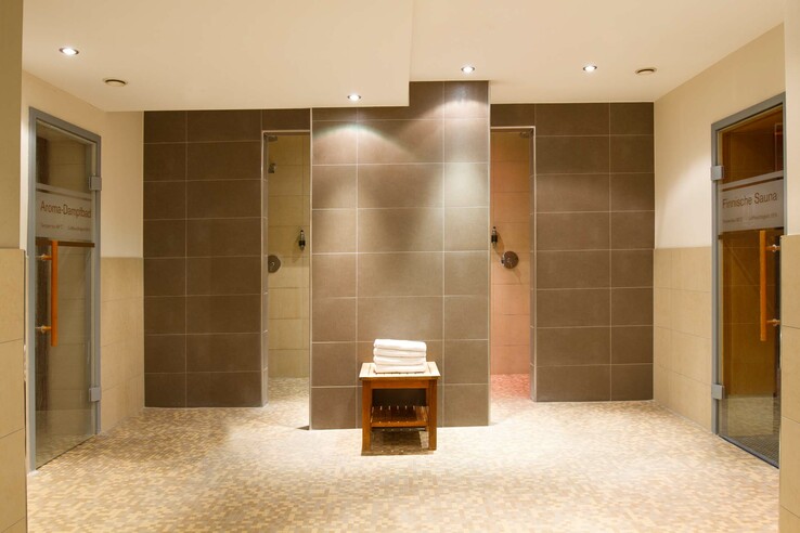 Moderner Spa-Bereich mit Aroma-Dampfbad, Finnischer Sauna und Handtüchern auf Holztisch im ATLANTIC Grand Hotel Travemünde.