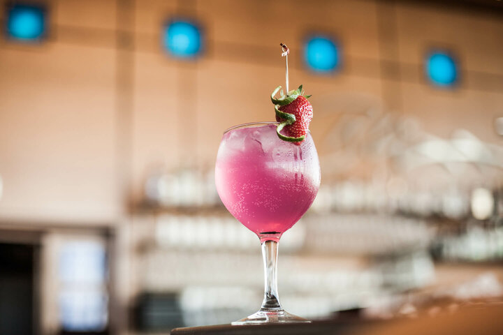 Cocktail in the ATLANTIC Hotel Airport Pink cocktail garnished with strawberry and lime, served at the ATLANTIC Hotel Airport Bremen.