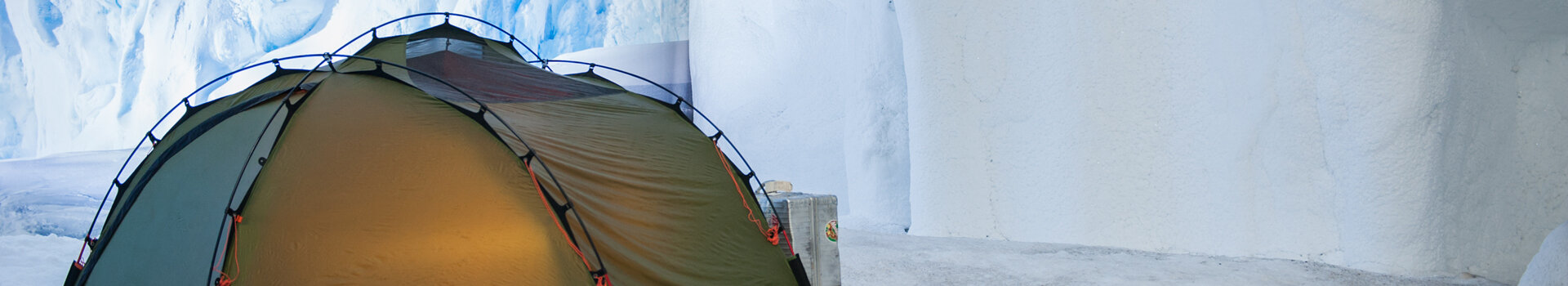 ATLANTIC Hotel SAIL City Aktion Klima to go Grünes Zelt in einer eisigen Höhle mit bläulich-weißen Wänden, sanftes Licht strahlt von innen.