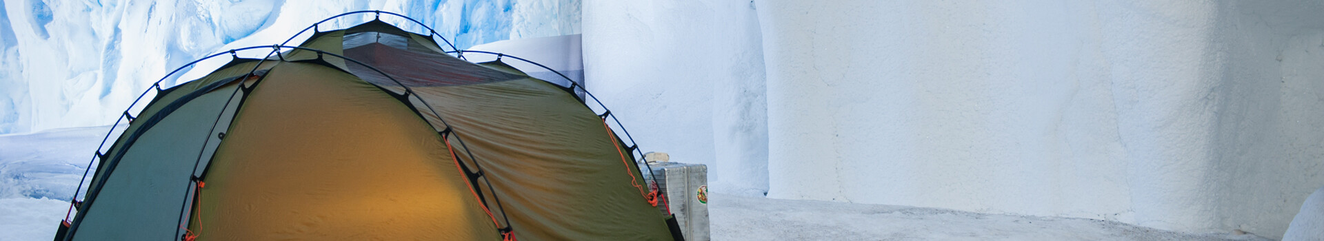 ATLANTIC Hotel SAIL City promotion climate to go Green tent in an icy cave with bluish-white walls, soft light radiating from inside.