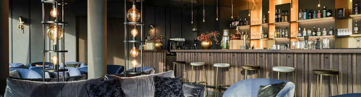Bar in the ATLANTIC Hotel Münster Elegant hotel bar with blue velvet furniture, stylish lamps and a well-stocked bar at the ATLANTIC Hotel Münster.