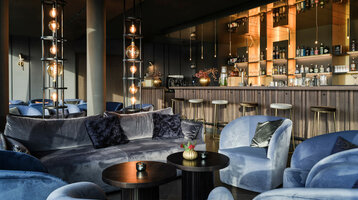 Bar in the ATLANTIC Hotel Münster Elegant hotel bar with blue velvet furniture, stylish lamps and a well-stocked bar at the ATLANTIC Hotel Münster.
