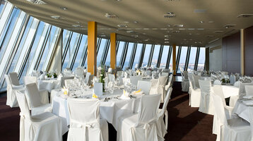 Marry over the roofs of Bremerhaven in the Captain´s Lounge of the ATLANTIC Hotel Sail City Bright event room in the ATLANTIC Hotel Sail City with white-clothed tables and a panoramic view of Bremerhaven.