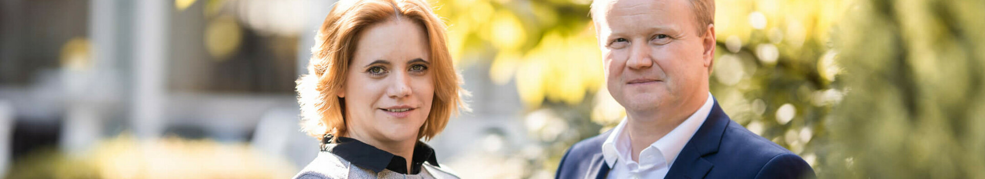 Direktor und Direktionsassistentin im ATLANTIC Hotel Landgut Horn Ein Mann und eine Frau stehen lächelnd im Garten des ATLANTIC Hotel Landgut Horn Bremen.