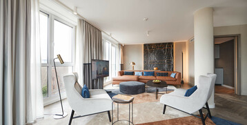 Elegant hotel room with large windows, modern furniture and stylish decor at the ATLANTIC Grand Hotel Bremen.