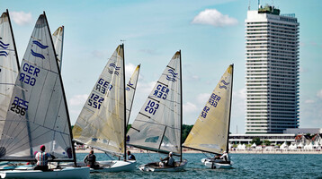 Segelboote auf der Ostsee vor dem ATLANTIC Grand Hotel Travemünde bei klarem Himmel.