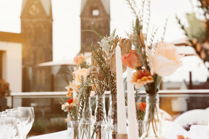 Blick auf die St. Petri Kirche von derDachterrasse des ATLANTIC Grand Hotel Bremen Elegante Tischdekoration mit Blumen und Kerzen vor den Türmen des Bremer Doms, ATLANTIC Grand Hotel Bremen.