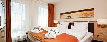 Innenansicht der Suite des ATLANTIC Hotel Kiel mit Doppelbett und luxuriöser Ausstattung