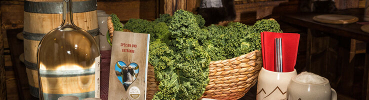 Rustic table with kale, sausages, menu and beer mug at the ATLANTIC Grand Hotel Bremen.