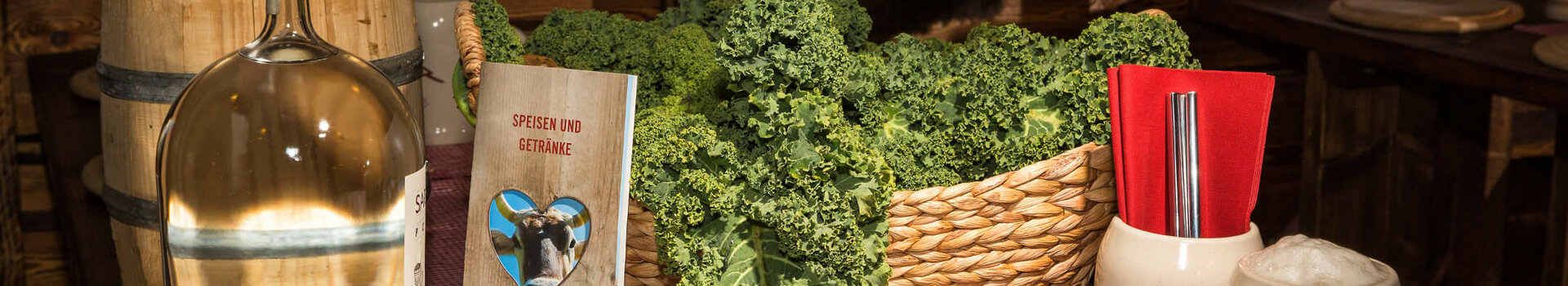 Grünkohl-Menü in der Almhütte am ATLANTIC Grand Hotel Bremen Rustic table with kale, sausages, menu and beer mug at the ATLANTIC Grand Hotel Bremen.