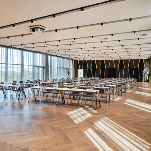 ATLANTIC Hotel Münster Engelsaal Tagung Moderner Konferenzraum im ATLANTIC Hotel Münster mit Reihen von Tischen, Stühlen und großen Fenstern.