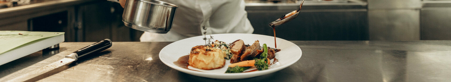 ATLANTIC Hotel Heidelberg Schlossgastronomie A chef prepares food in a professional kitchen