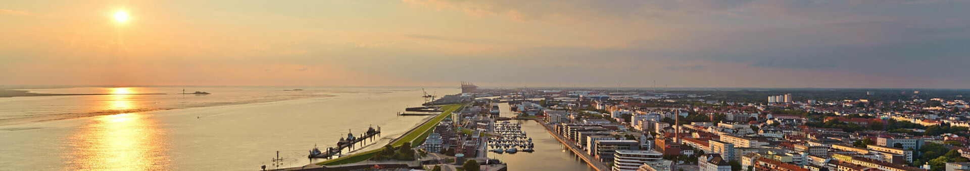 View over the new harbour in Bremerhaven View of Bremerhaven from the ATLANTIC Hotel Sail City at sunset, with harbor, river and city panorama.