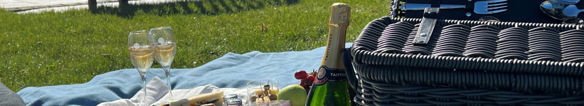Picknicken mit Picknickkorb im ATLANTIC Grand Hotel Travemünde Picknick auf Rasen mit Decke, Sekt, Snacks und Korb vor dem ATLANTIC Grand Hotel Travemünde.