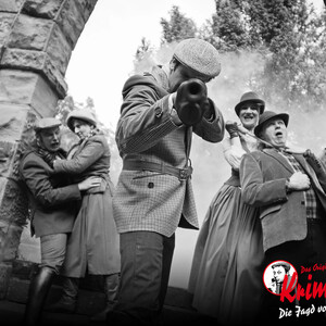 Scenic murder mystery dinner: people in period dress, dramatic scene with smoke, ATLANTIC Grand Hotel Travemünde.