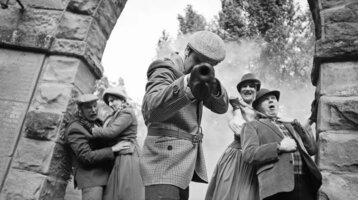 Szenisches Krimidinner: Personen in historischer Kleidung, dramatische Szene mit Rauch, ATLANTIC Grand Hotel Travemünde.