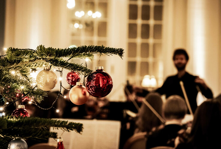 Weihnachtsbaum mit Kugeln, im Hintergrund unscharf ein Orchester im ATLANTIC Grand Hotel Travemünde.