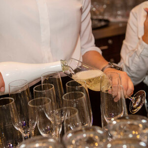 Ein Kellner schenkt Sekt in Gläser ein, elegant gedeckter Tisch im ATLANTIC Hotel Sail City.