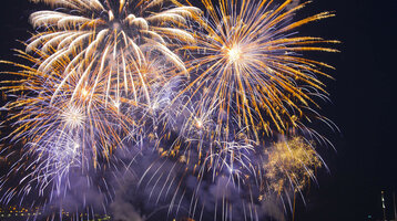 Farbenfrohes Feuerwerk erleuchtet den Nachthimmel über dem Wasser, festliche Stimmung am ATLANTIC Grand Hotel Travemünde.