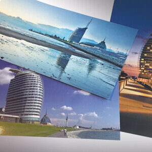 View of the ATLANTIC Hotel Sail City in Bremerhaven by day and night, with the sea and promenade in the background.