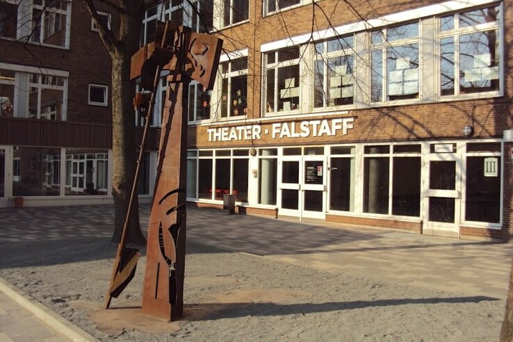 Metal sculpture in front of the entrance to the Falstaff Theater, surrounded by brick buildings and trees. © bremer shakespeare company