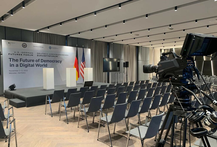 Konferenzraum im ATLANTIC Hotel Münster mit Bühne, Rednerpulten, Kameras und Stuhlreihen für ein Zukunftsforum.