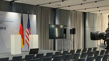 Konferenzraum im ATLANTIC Hotel Münster mit Bühne, Rednerpulten, Kameras und Stuhlreihen für ein Zukunftsforum.