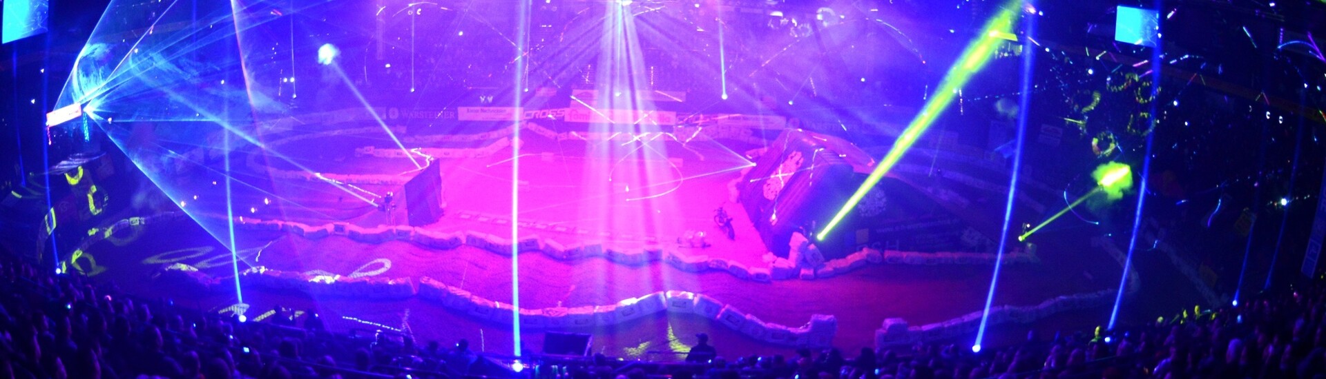 Innenraum der Wunderino Arena Kiel während einer Veranstaltung mit Lichtshow Große Veranstaltungshalle mit farbenfroher Lichtshow und Publikum in den Rängen.