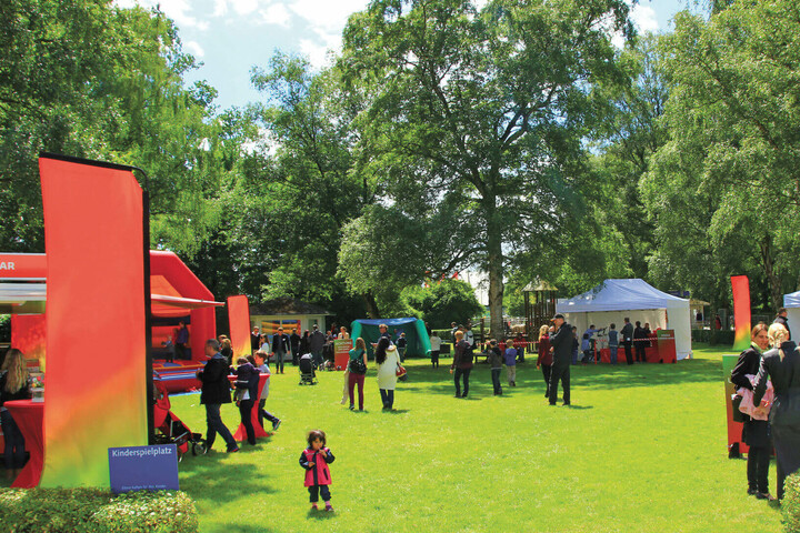 sommerfest in front of the ATLANTIC Hotel Galopprennbahn Green park with visitors, stands and a children's playground at the ATLANTIC Hotel Galopprennbahn in Bremen.