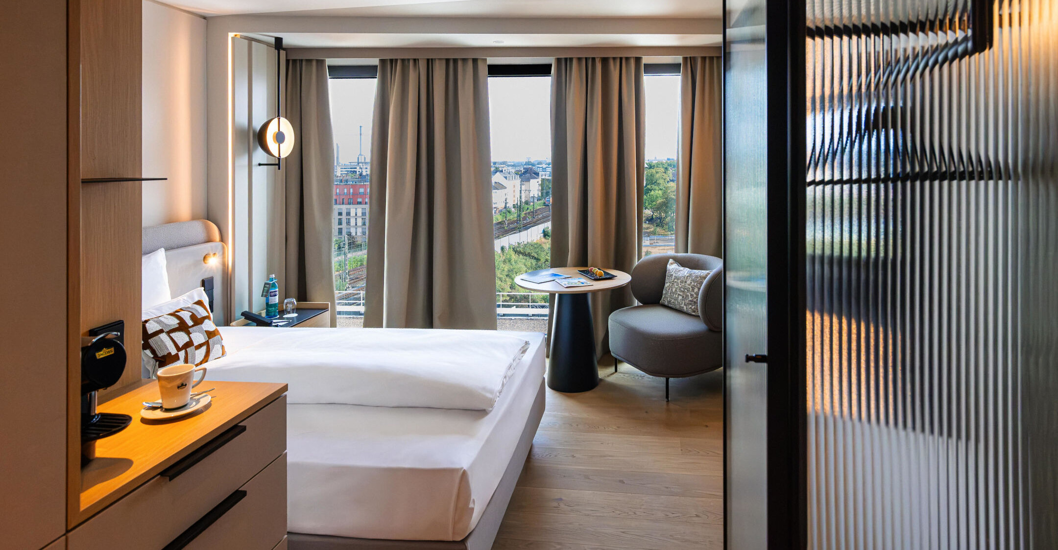 Sessel, Kaffeemaschine und Bett im Einzelzimmer.