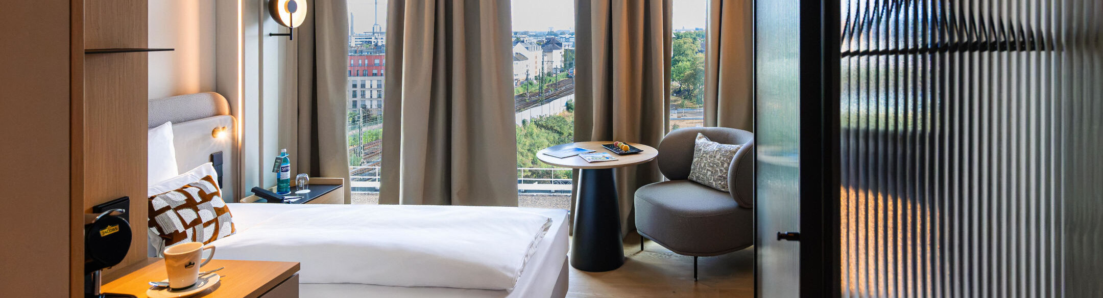 Sessel, Kaffeemaschine und Bett im Einzelzimmer.