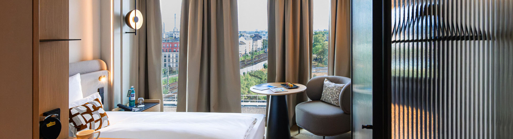 An armchair, a coffee machine and a bed in a single room.