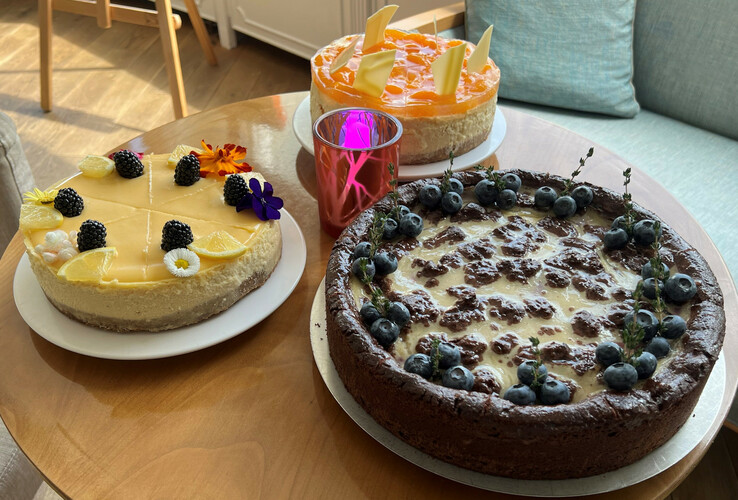 Three decorative cakes on a wooden table in the ATLANTIC Grand Hotel Travemünde.