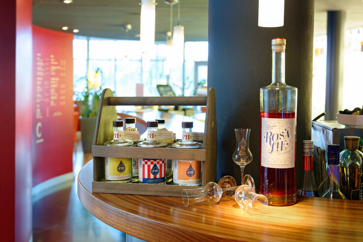 Getränkeauswahl mit Spirituosen und Gläsern auf Holztresen im ATLANTIC Hotel Universum Bremen.