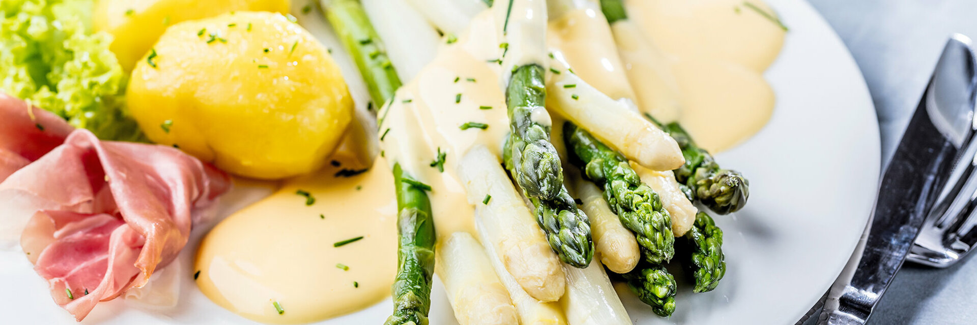 Grüner und weißer Spargel mit Sauce Hollandaise, Salzkartoffeln und Schinken.