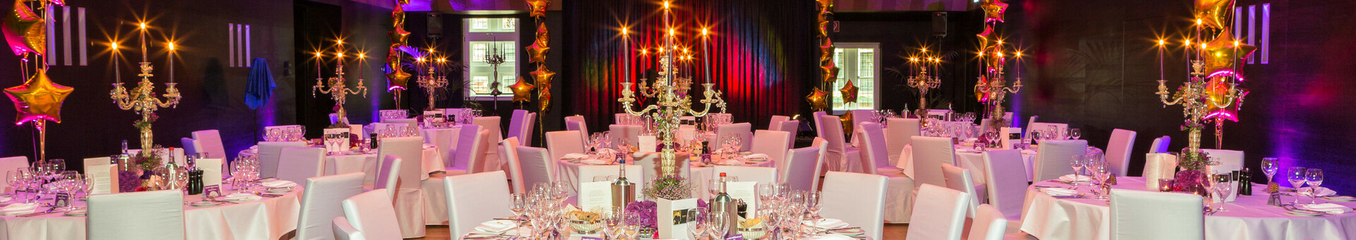 Function room "Goldener Saal" in the ATLANTIC Grand Hotel Bremen Festively decorated banquet hall in the ATLANTIC Grand Hotel Bremen with round tables, white chair covers and candlesticks.