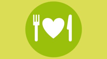 Grüner Kreis mit weißem Herz zwischen Gabel und Messer, symbolisiert kulinarische Angebote.