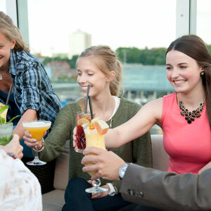 DECK 8 bar in Kiel terrace cocktails Group of people toasting with cocktails on a terrace of the ATLANTIC Hotel Kiel.