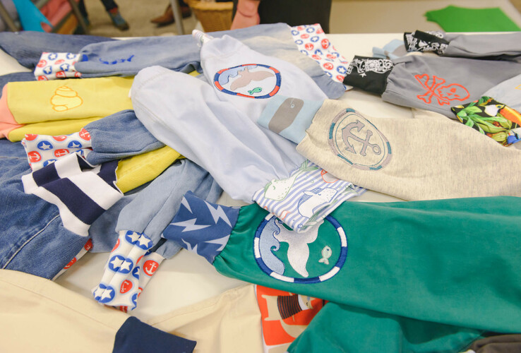 Colorful fabrics with maritime motifs and patterns lie on a table in the ATLANTIC Hotel Sail City.