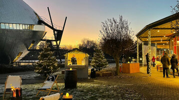 Weihnachtsfeier im ATLANTIC Hotel Universum Weihnachtlich geschmückter Außenbereich des ATLANTIC Hotel Universum bei Sonnenuntergang, mit Lichterketten und Ständen.