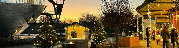 Weihnachtsfeier im ATLANTIC Hotel Universum Weihnachtlich geschmückter Außenbereich des ATLANTIC Hotel Universum bei Sonnenuntergang, mit Lichterketten und Ständen.