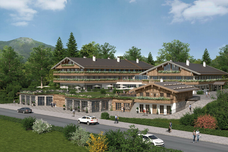 Modern Alpine-style hotel with wooden façade, surrounded by trees and mountains, people walking on the sidewalk.