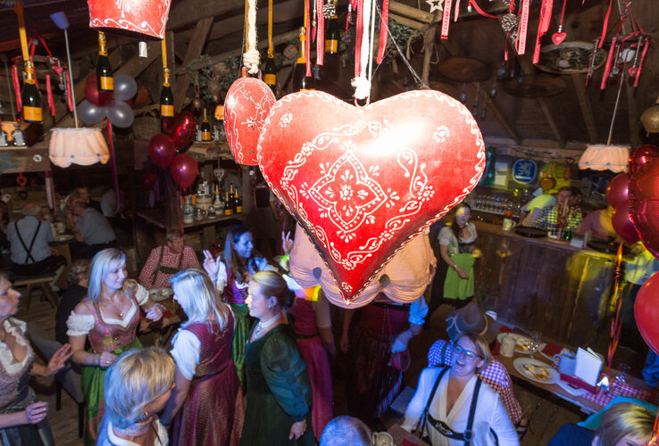 A cosy, rustic restaurant with wooden tables, decorated with red lanterns and heart motifs, at the ATLANTIC Grand Hotel Bremen.