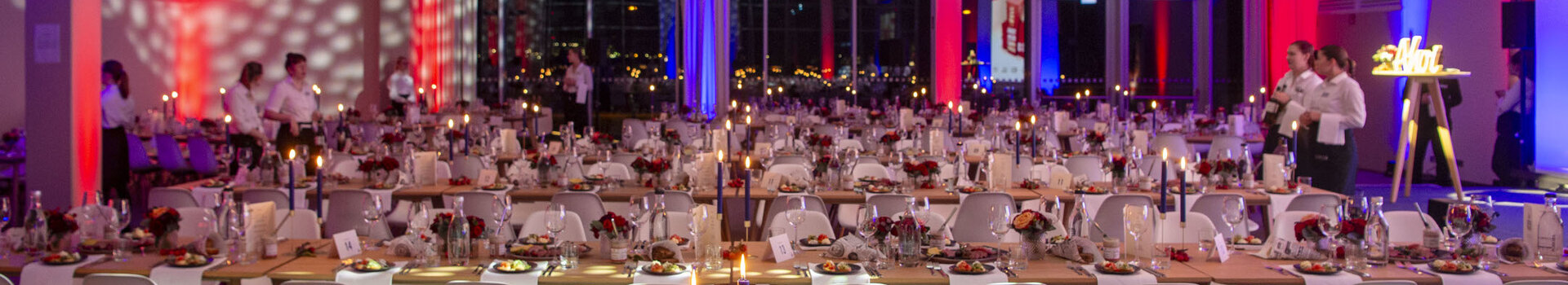 Verleihung des Landestourismuspreises 2023 | ATLANTIC Hotel Sail City Festlich gedeckter Bankettsaal im ATLANTIC Hotel Sail City mit Kerzenlicht und bunter Beleuchtung.