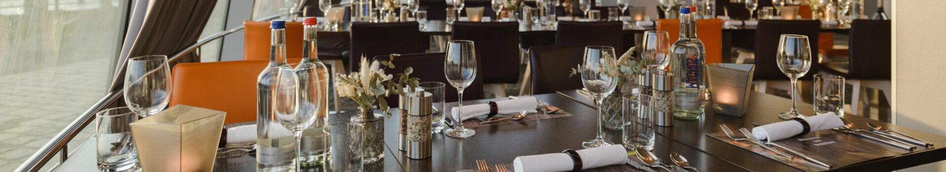 Modernes Restaurant mit elegant gedeckten Tischen, großen Fenstern und Blick auf die Küste im ATLANTIC Hotel Sail City.