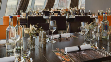 Modernes Restaurant mit elegant gedeckten Tischen, großen Fenstern und Blick auf die Küste im ATLANTIC Hotel Sail City.