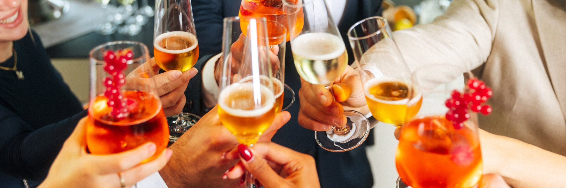 Menschen stoßen mit Sekt und Aperolgläsern an.