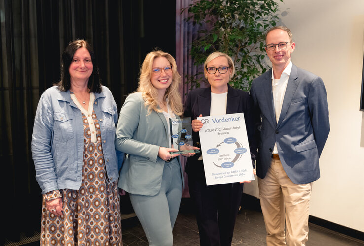 Das Team vom ATLANTIC Grand Hotel Bremen freuen sich über den Preis, den sie in die Kamera halten.