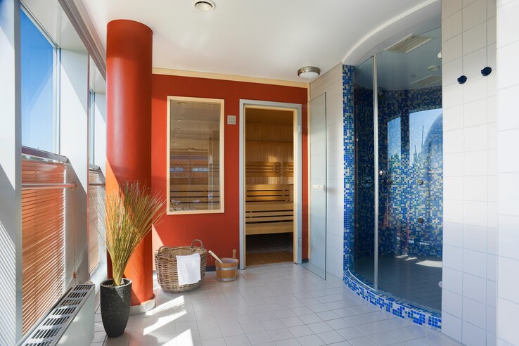 Moderner Wellnessbereich im ATLANTIC Hotel Universum mit Sauna, Regendusche und hellen Fenstern.